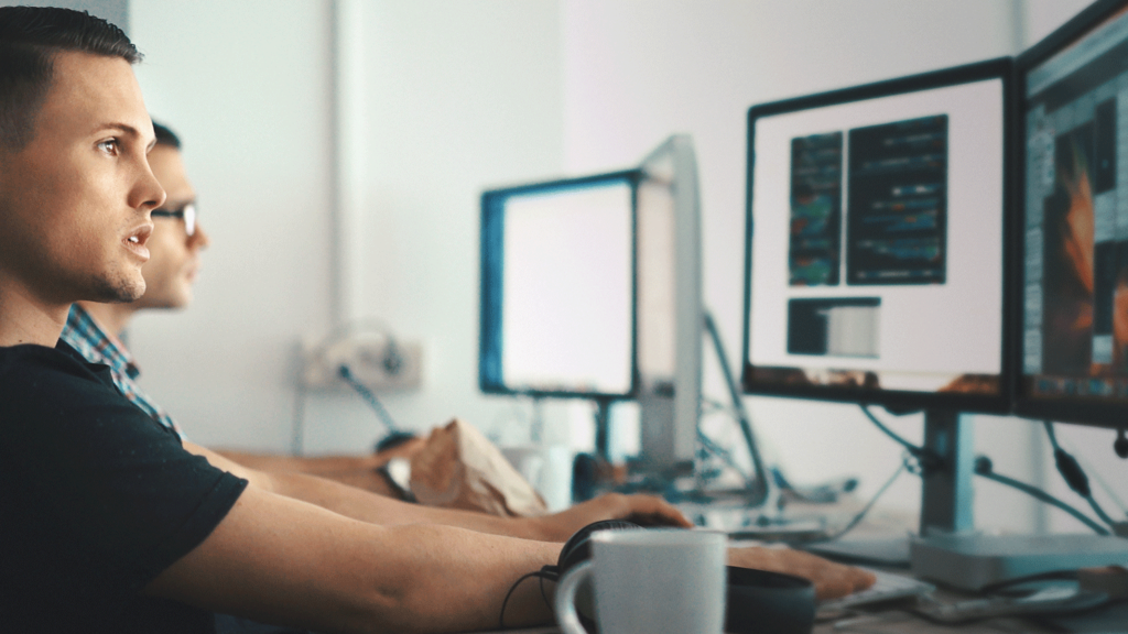 Person working at multiple desktop monitors