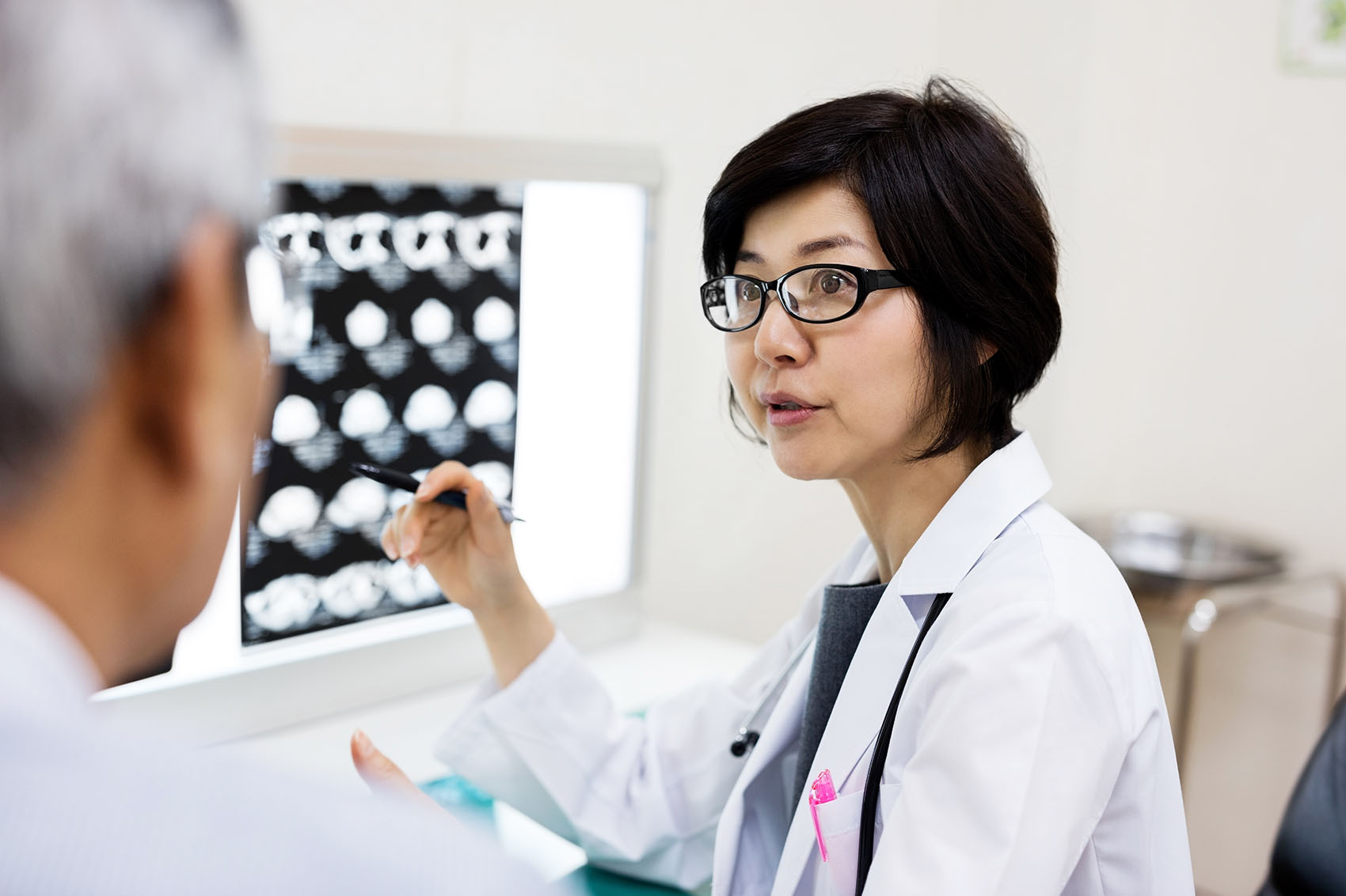 Female doctor discussing with man over MRIs in hospital