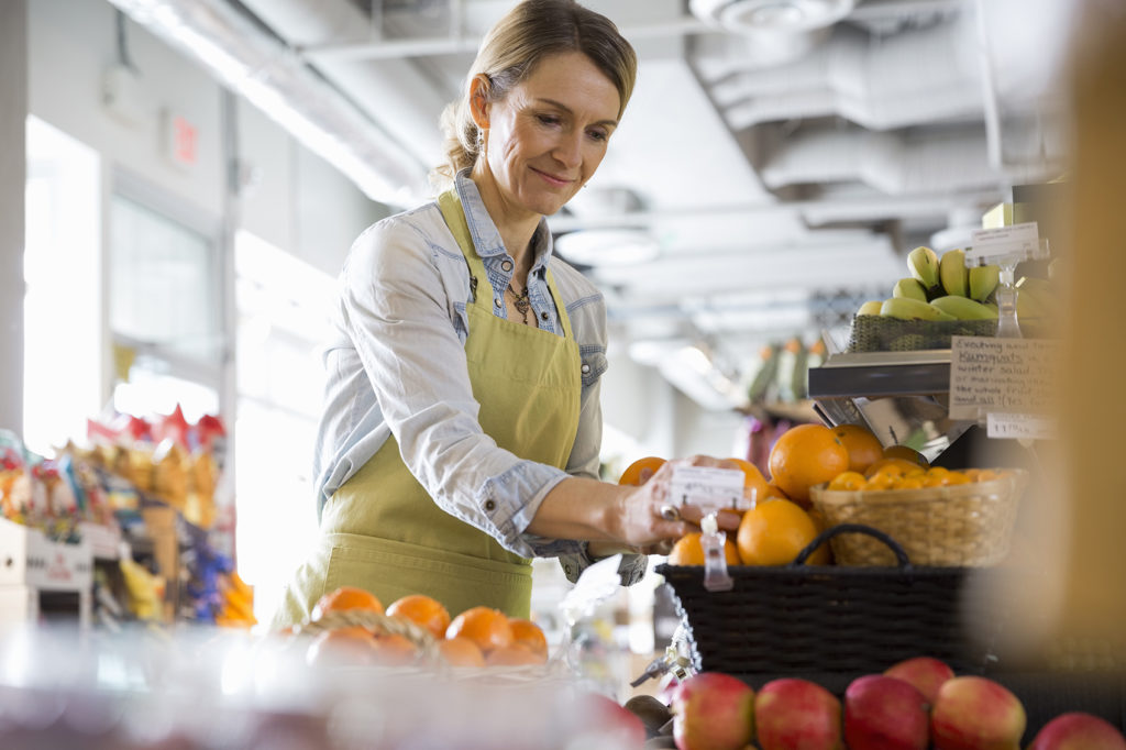 Worker arranging produce in market