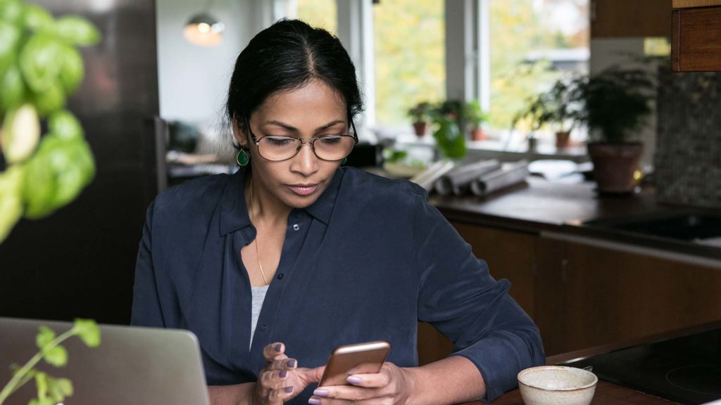 Woman at home looking at her phone screen