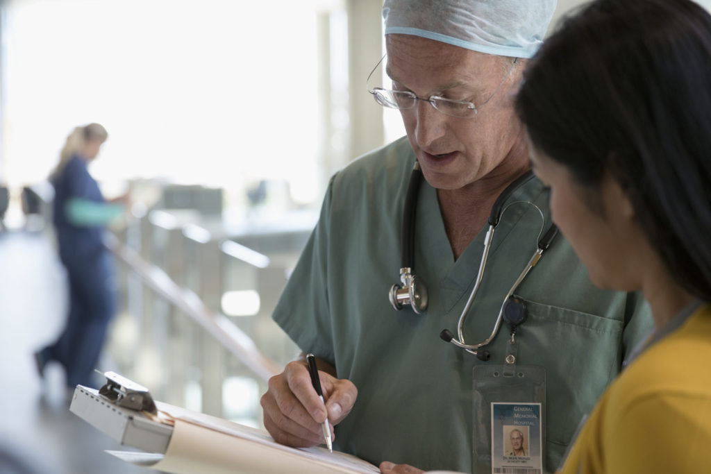 Surgeon and doctor discussing medical record in hospital