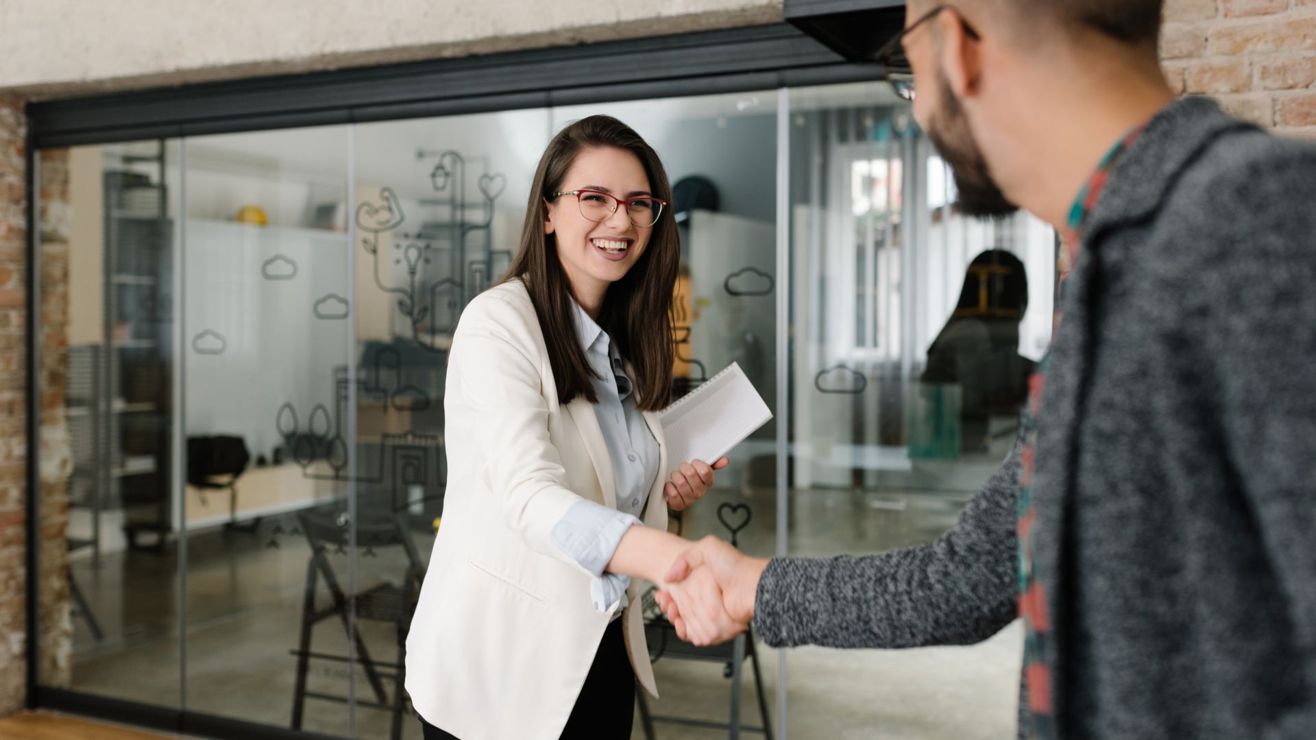 Woman smiling and shaking someone's hand at an interview