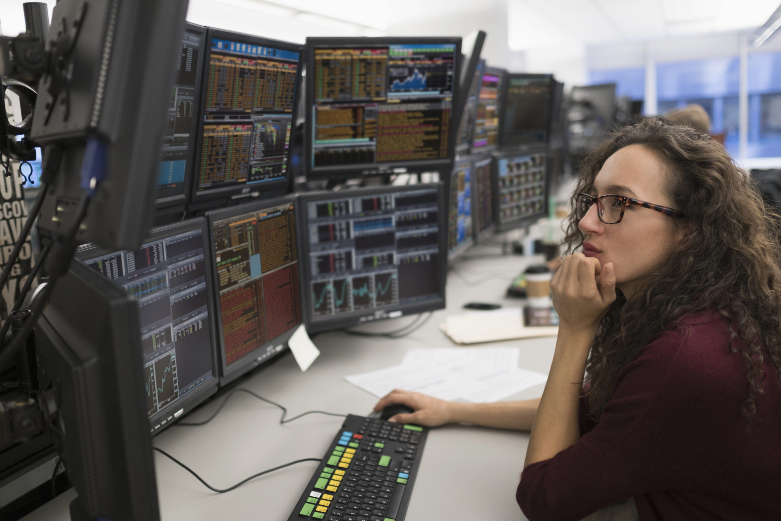 Employee analyzing computer data on a bank of computer screens