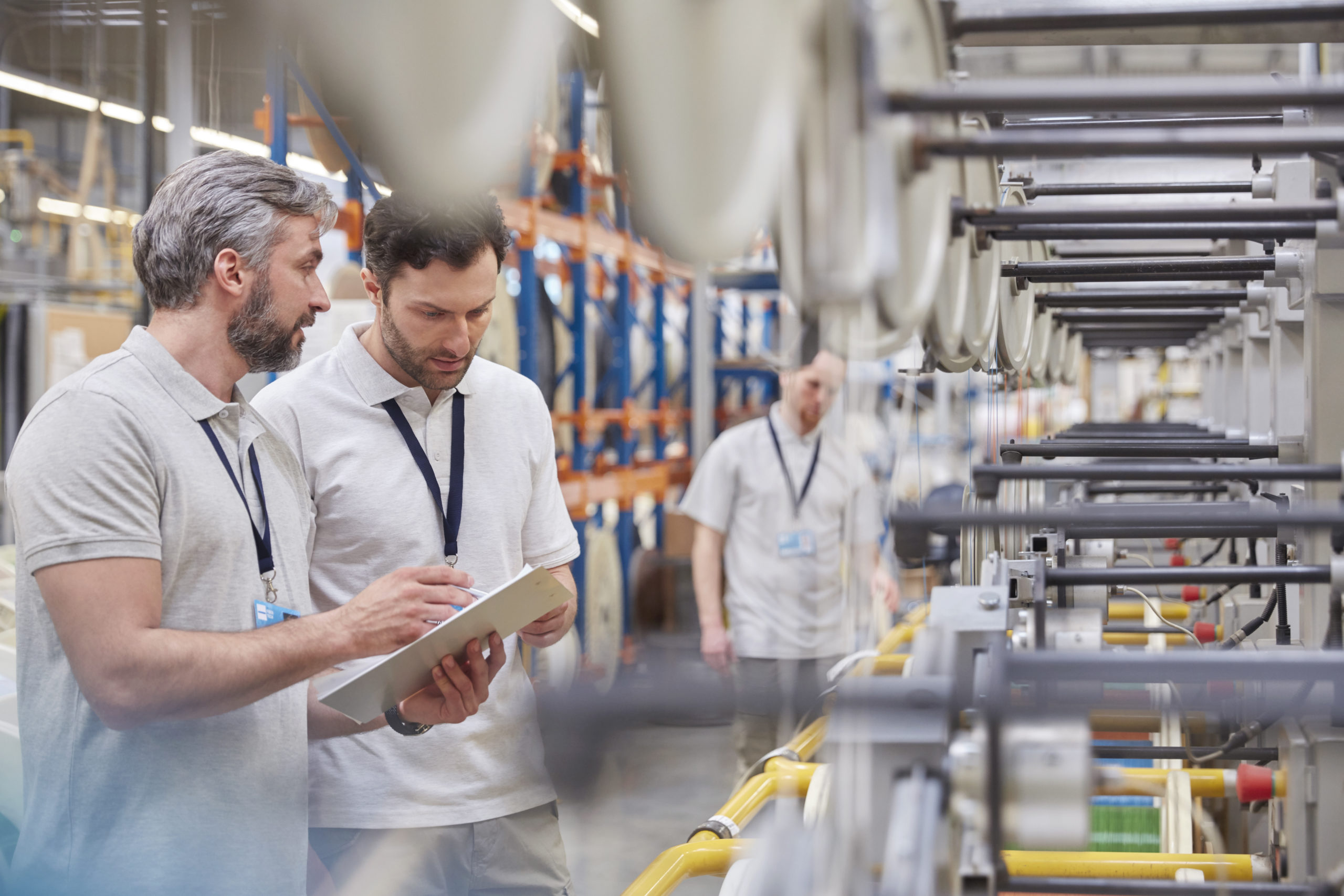 Coworkers discussing work in factory setting 