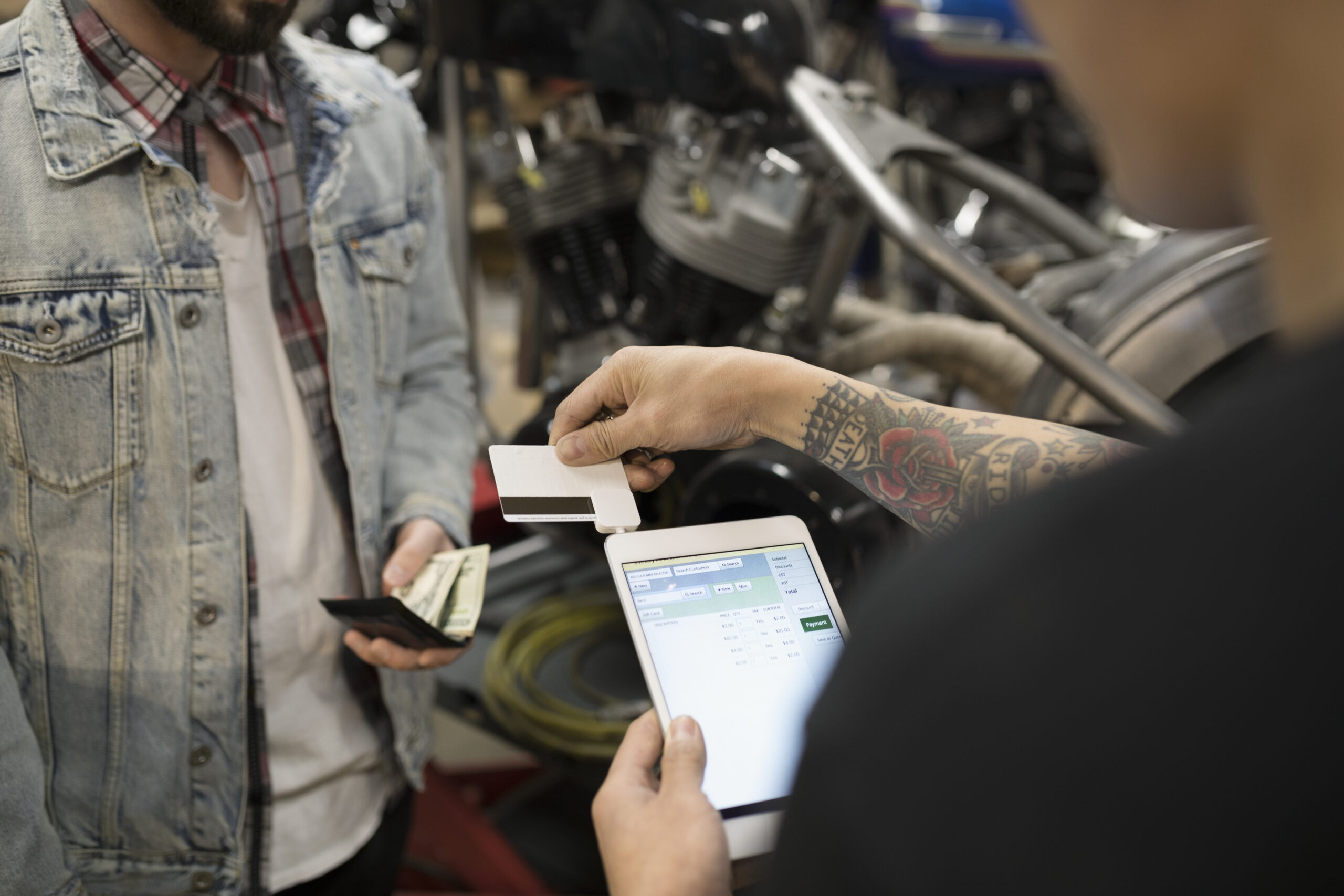 Retailer swiping credit card using digital tablet 