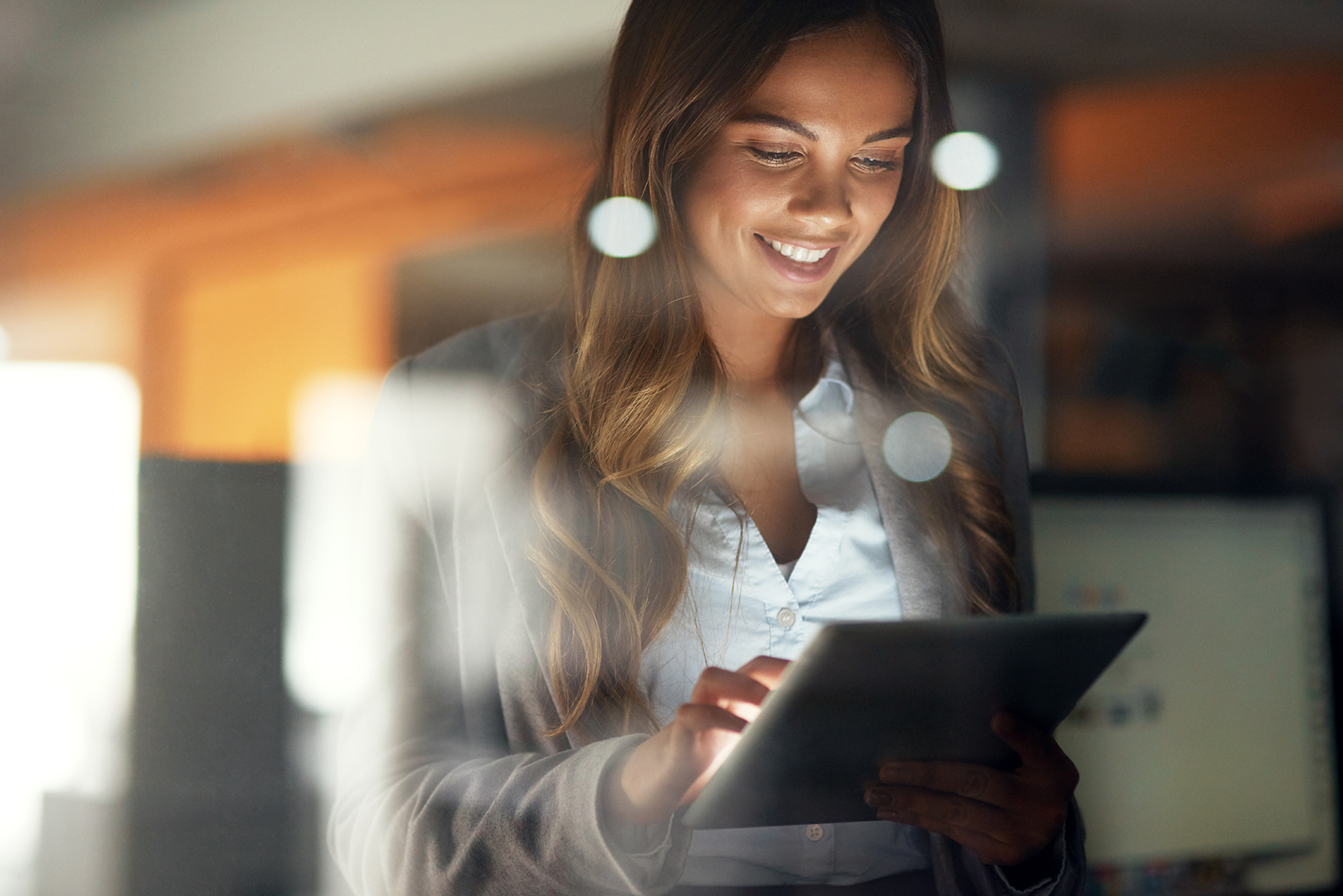 Person in office happily using tablet