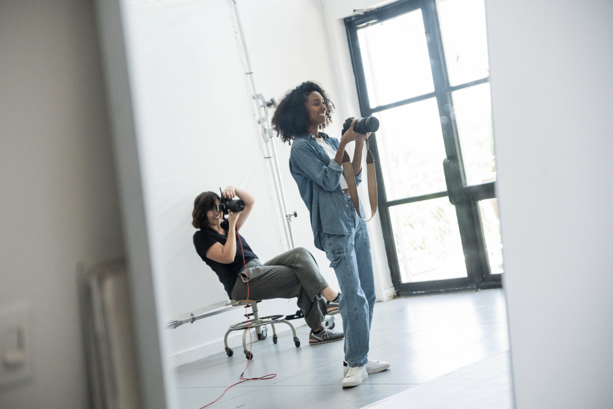 Two photographers holding cameras on set 