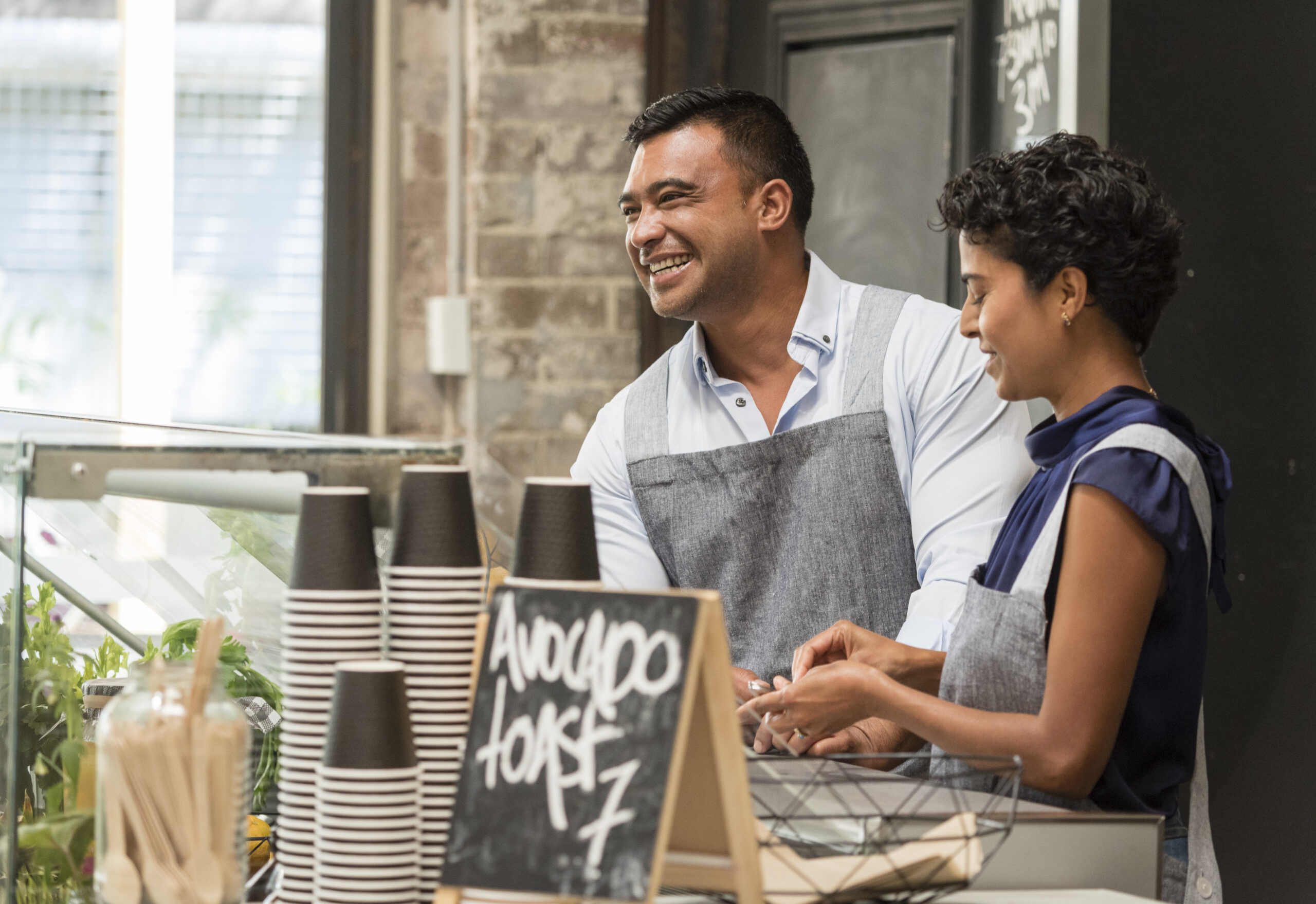 Smiling restaurant workers behind the counter at a coffee shop