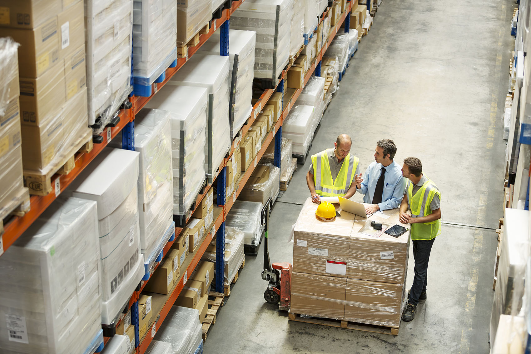 High angle view of supervisor discussing with workers at distribution warehouse