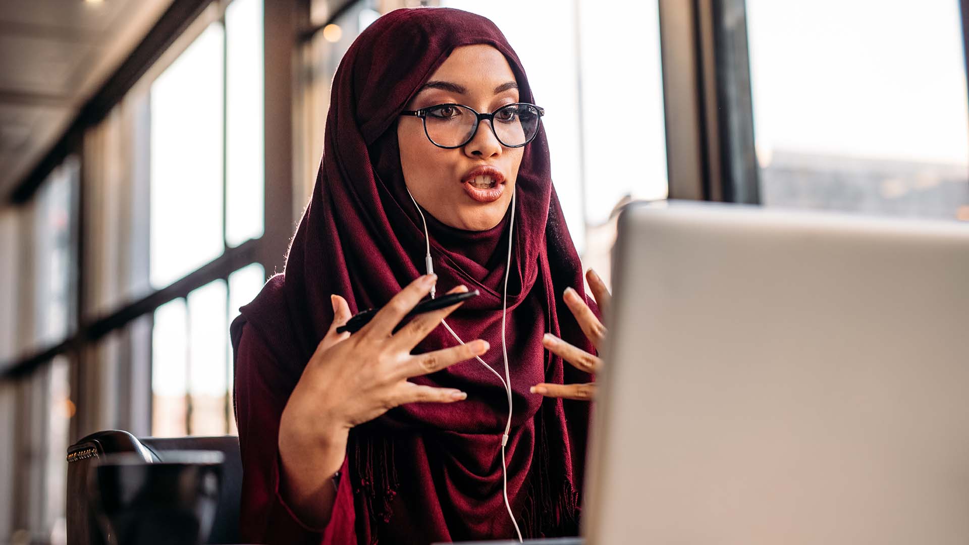 Businesswoman in hijab having a video chat on laptop.