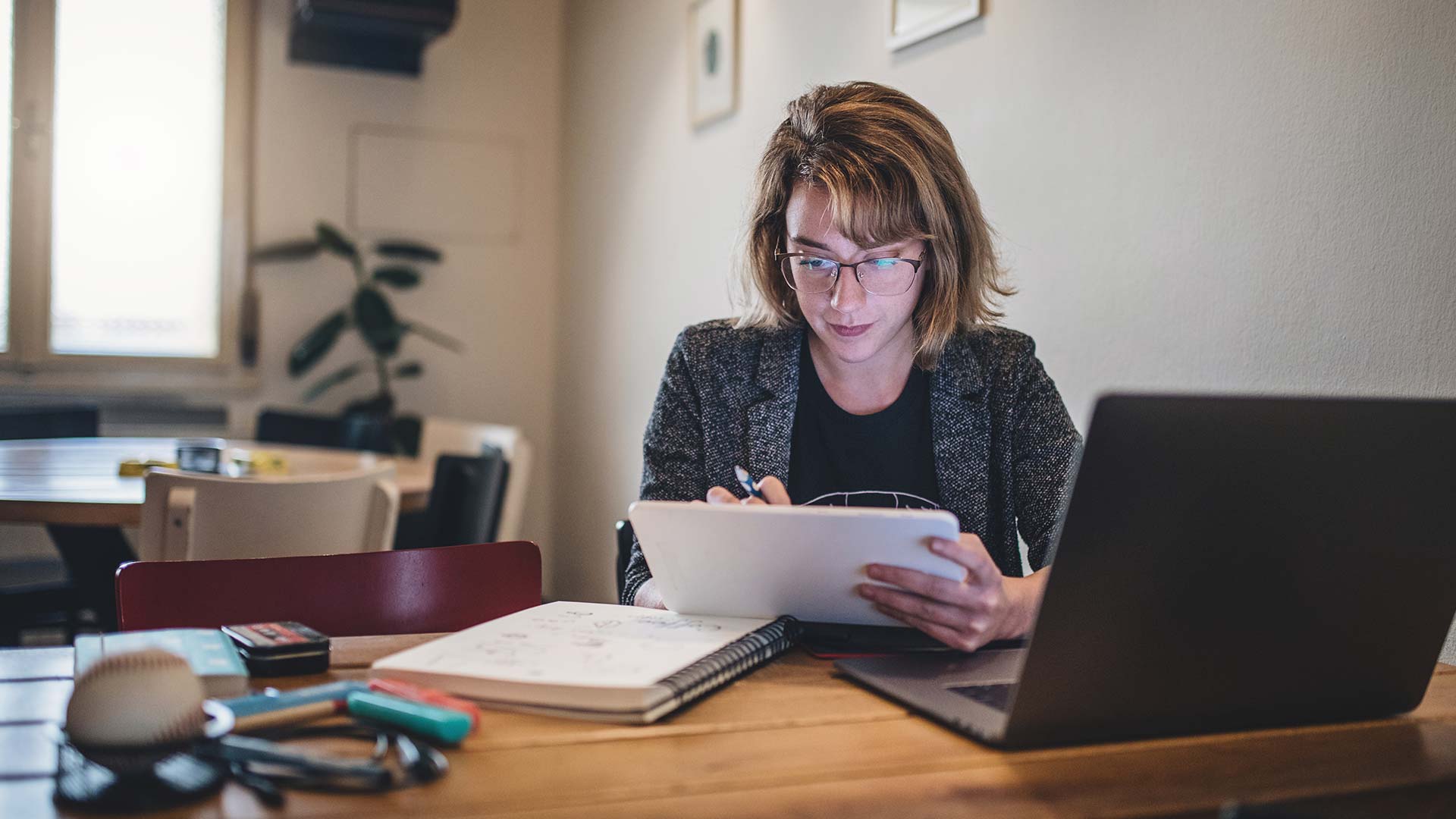 Photo of a woman sitting at desk looking at her computer