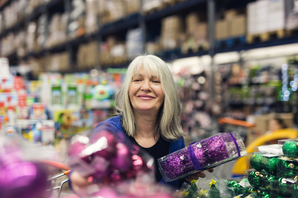 Store worker putting holiday decor in proper place