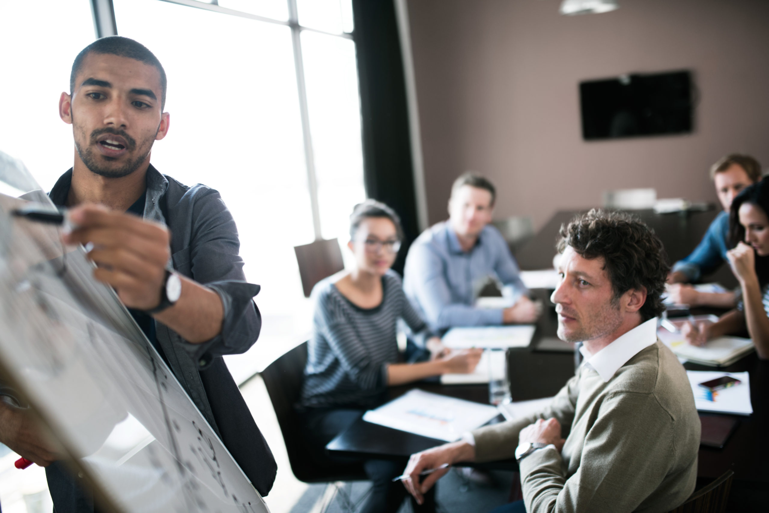 Person giving a business presentation using a whiteboard.