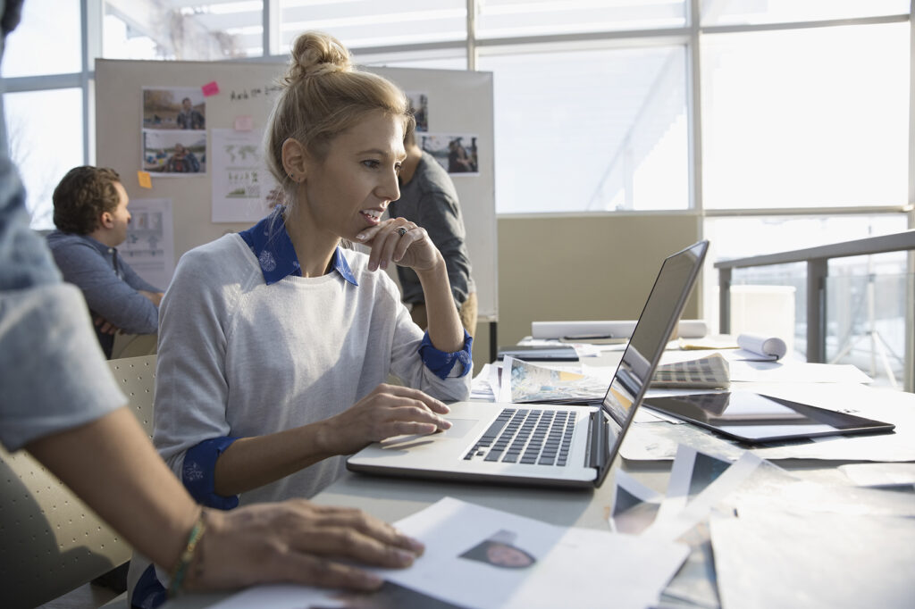 Image of person sitting in office doing working on laptop