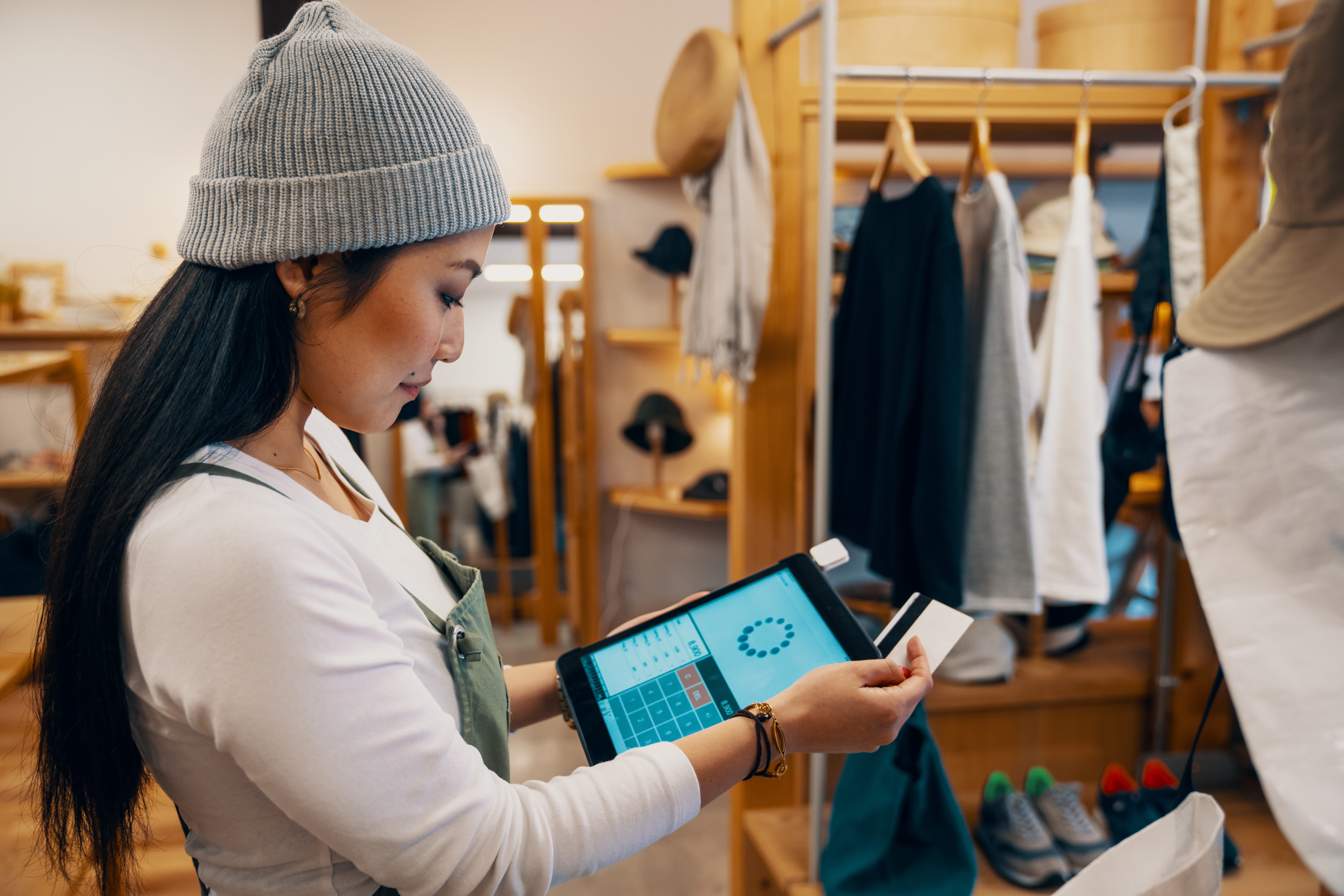 Retail shop clerk taking a mobile credit card payment on a digital tablet