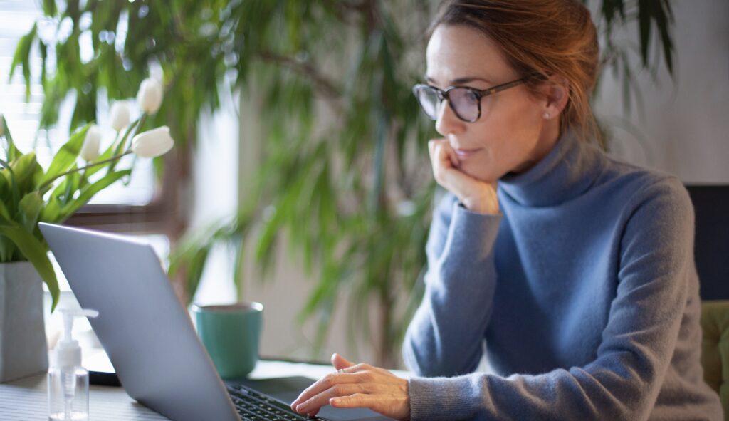 Personne utilisant un ordinateur portable depuis son bureau à domicile