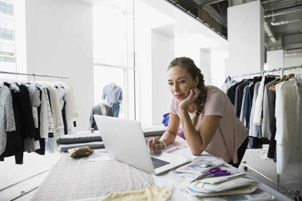 Une femme travaillant dans un magasin regarde un écran d'ordinateur