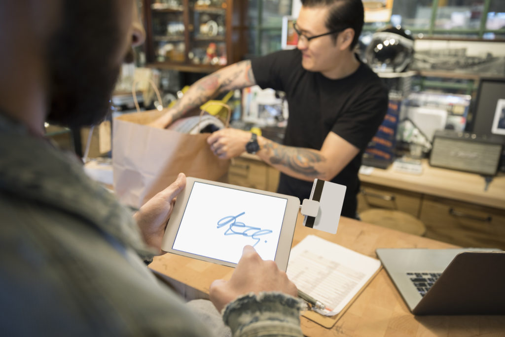 デジタル タブレットでタッチ署名を使用している顧客