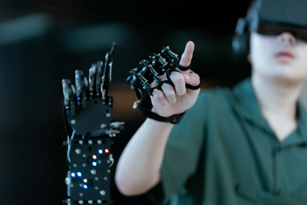 デモンストレーションのようにロボットアームを操作しながら指を指している人