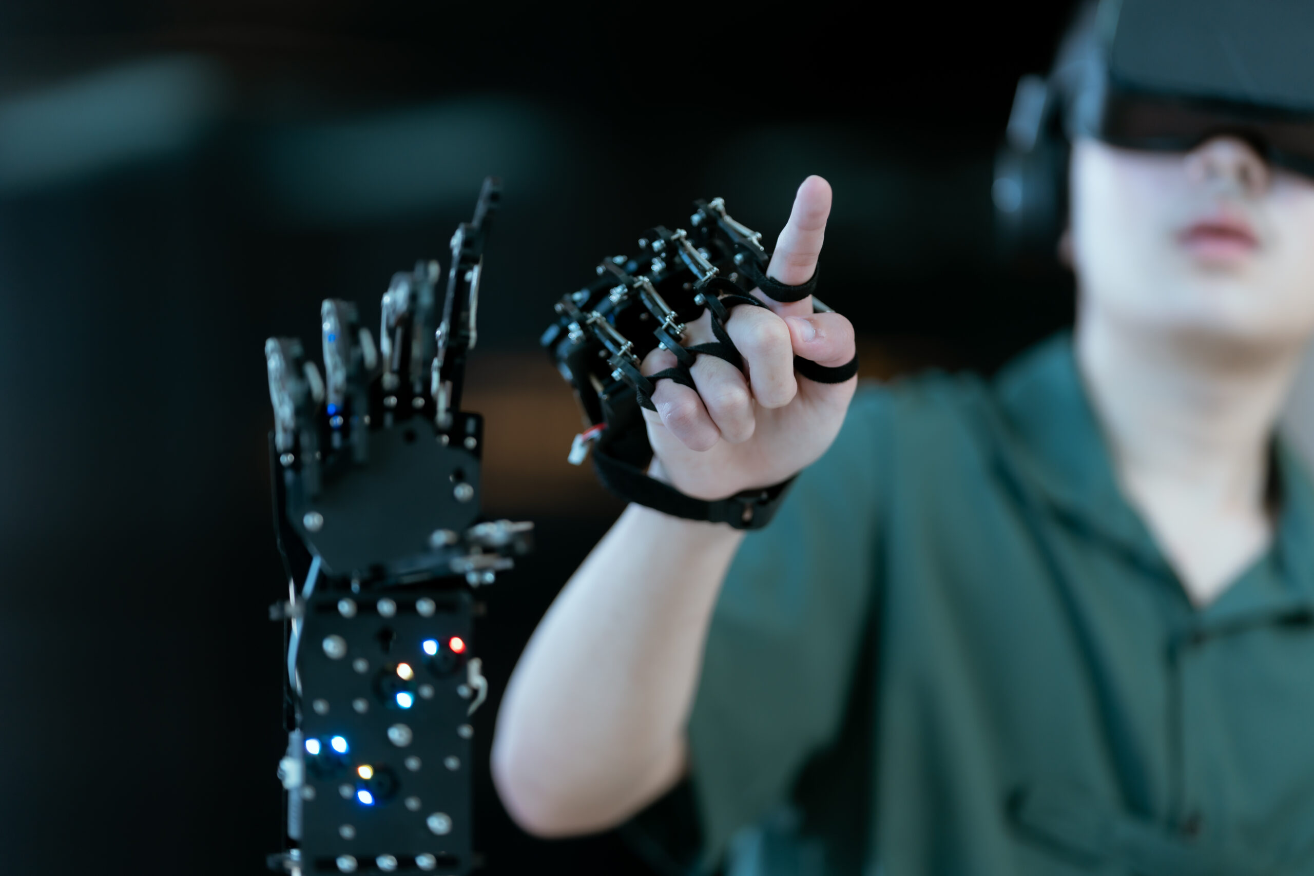 デモンストレーションのようにロボットアームを操作しながら指を指している人