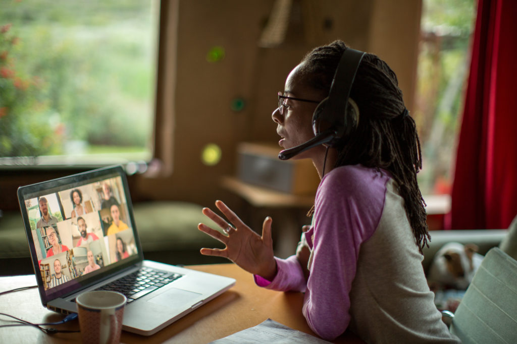 Woman working from home with a laptop and headset