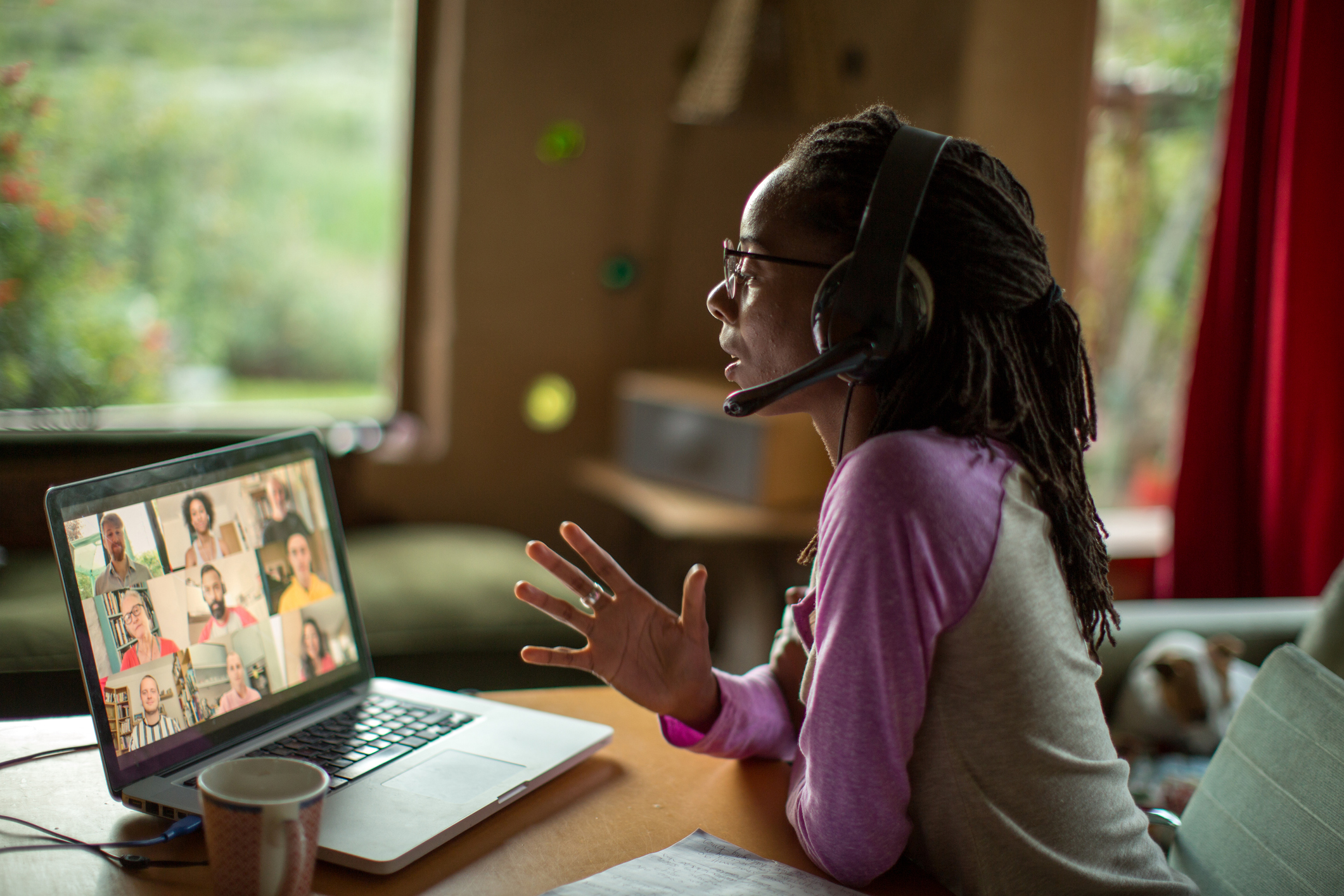 Woman working from home with a laptop and headset