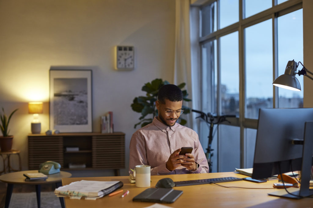 Man using phone while sitting at home office