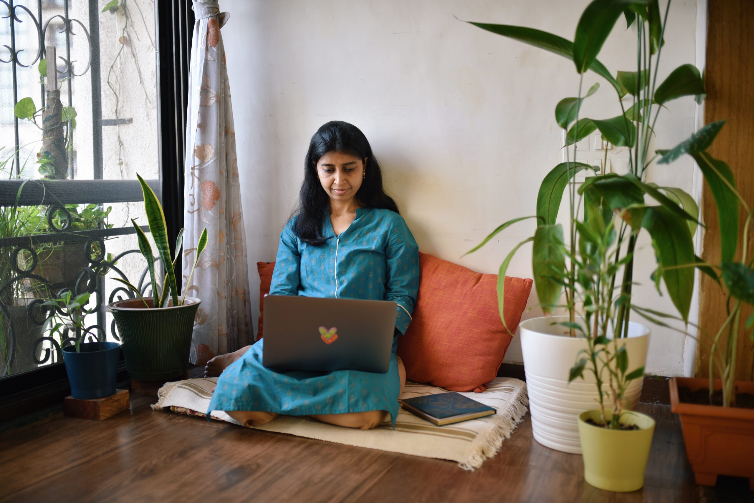 Person working on laptop sitting next to window