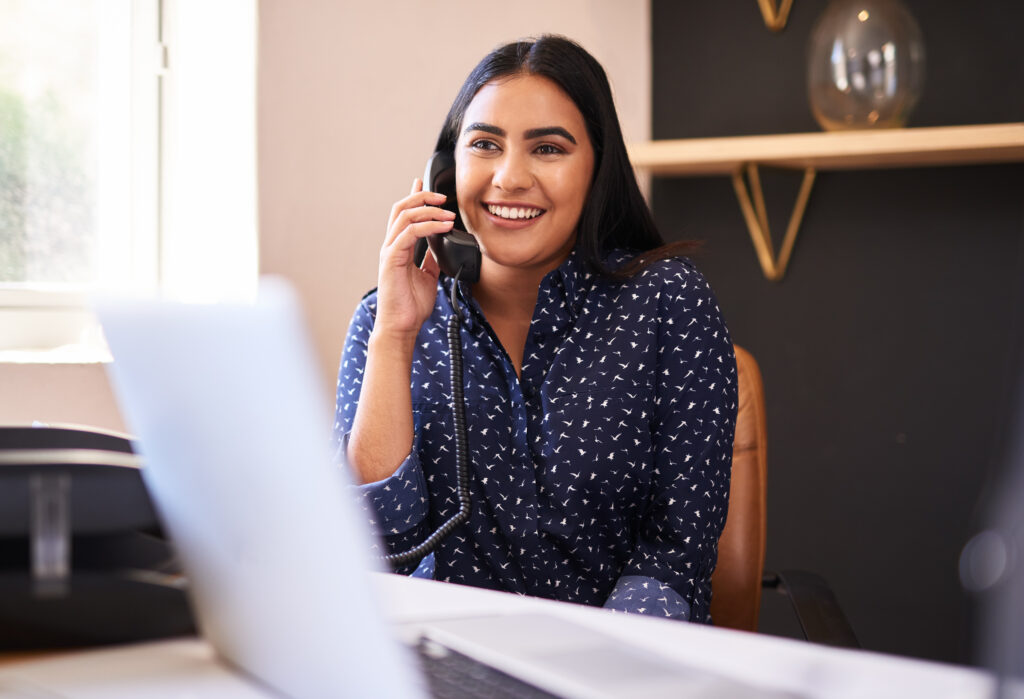 Young businessperson smiling while taking a call in the office