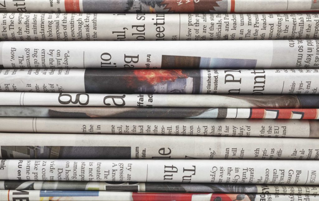Newspapers stacked on top of each other.