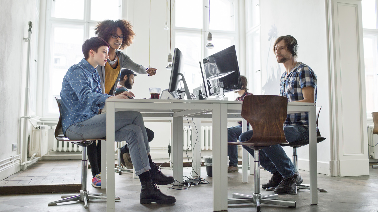 A team of team people working at their desks in an open plan office.