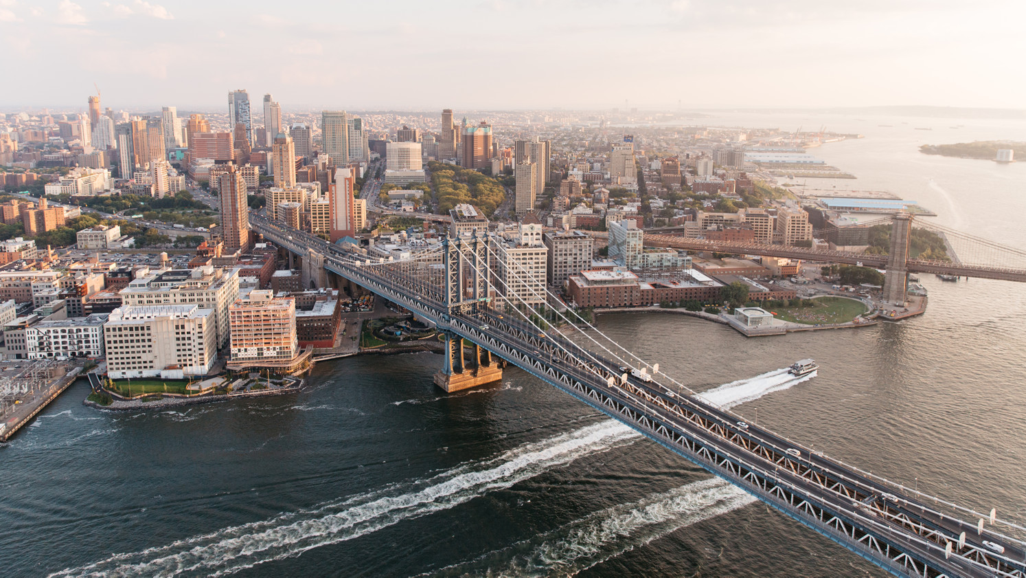 An aerial view of the New York skyline with the Brooklyn Bridge in the foreground.