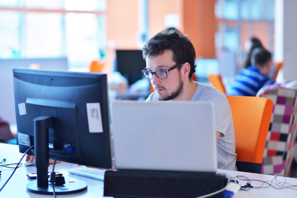 Man working at a computer in an open plan office