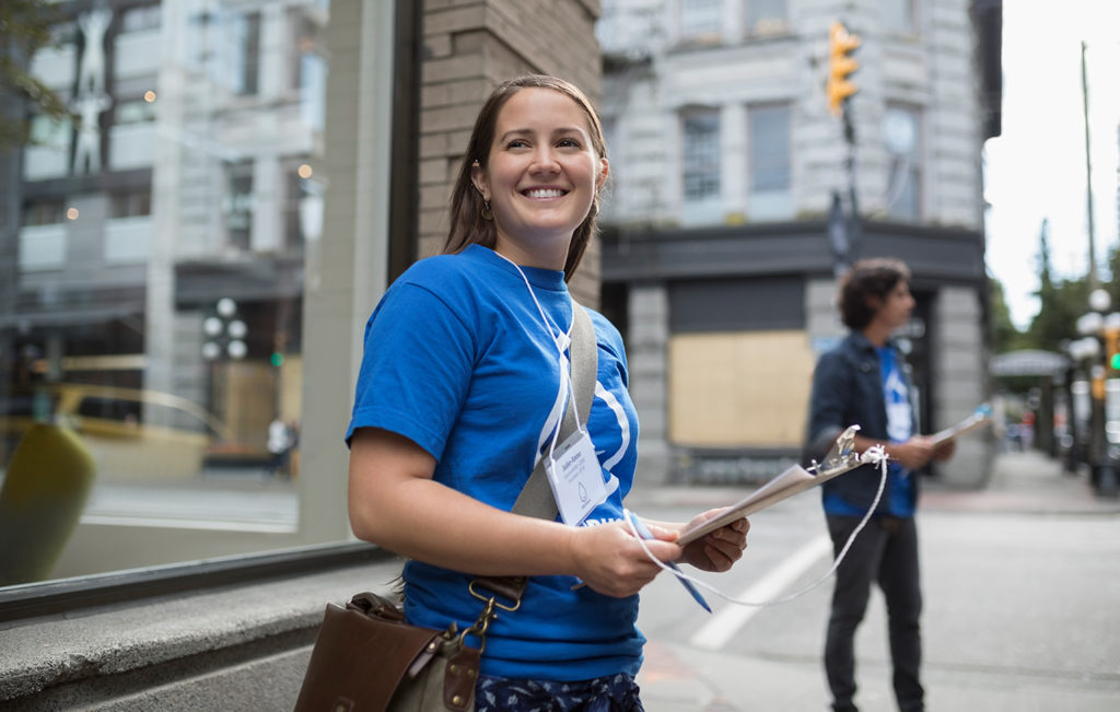 A young political canvasser standing on a city street