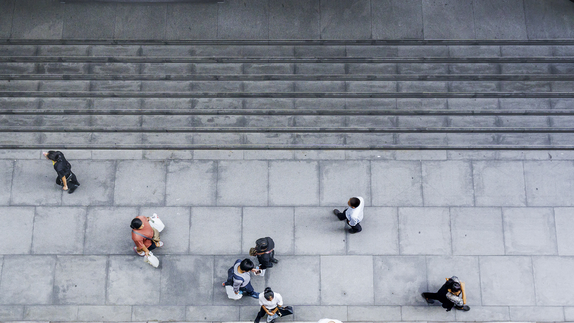 Aerial view of people walking on a wide sidewalk.