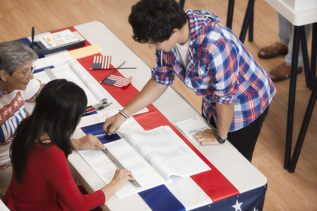 Man arriving at registration desk in polling place