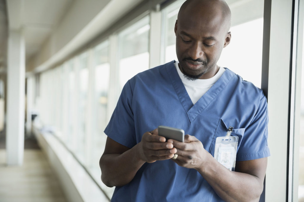 Surgeon text messaging at window