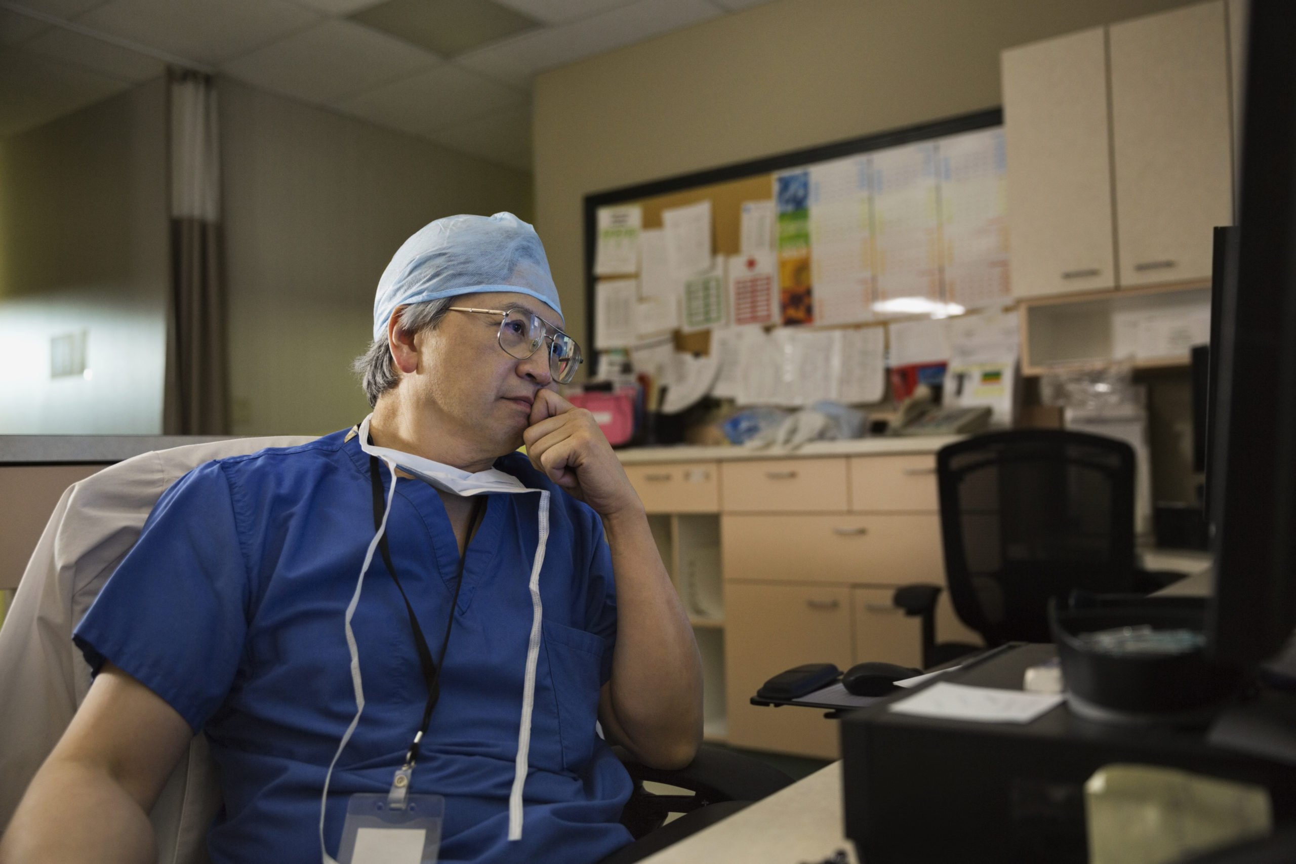 Surgeon in clinic using a desktop computer.