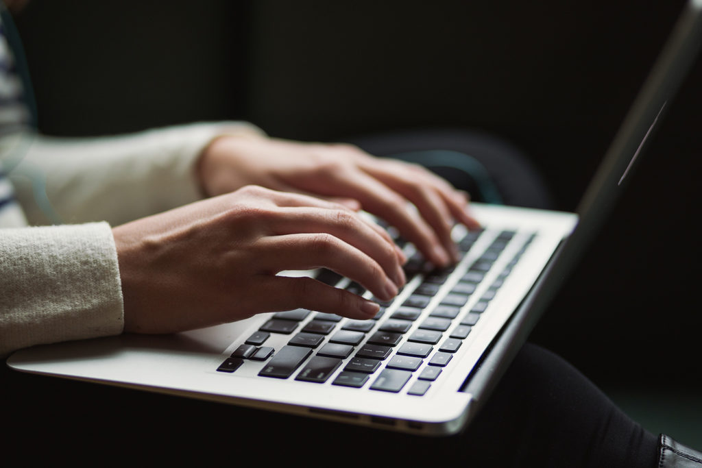 Close up of hands typing on a laptop.