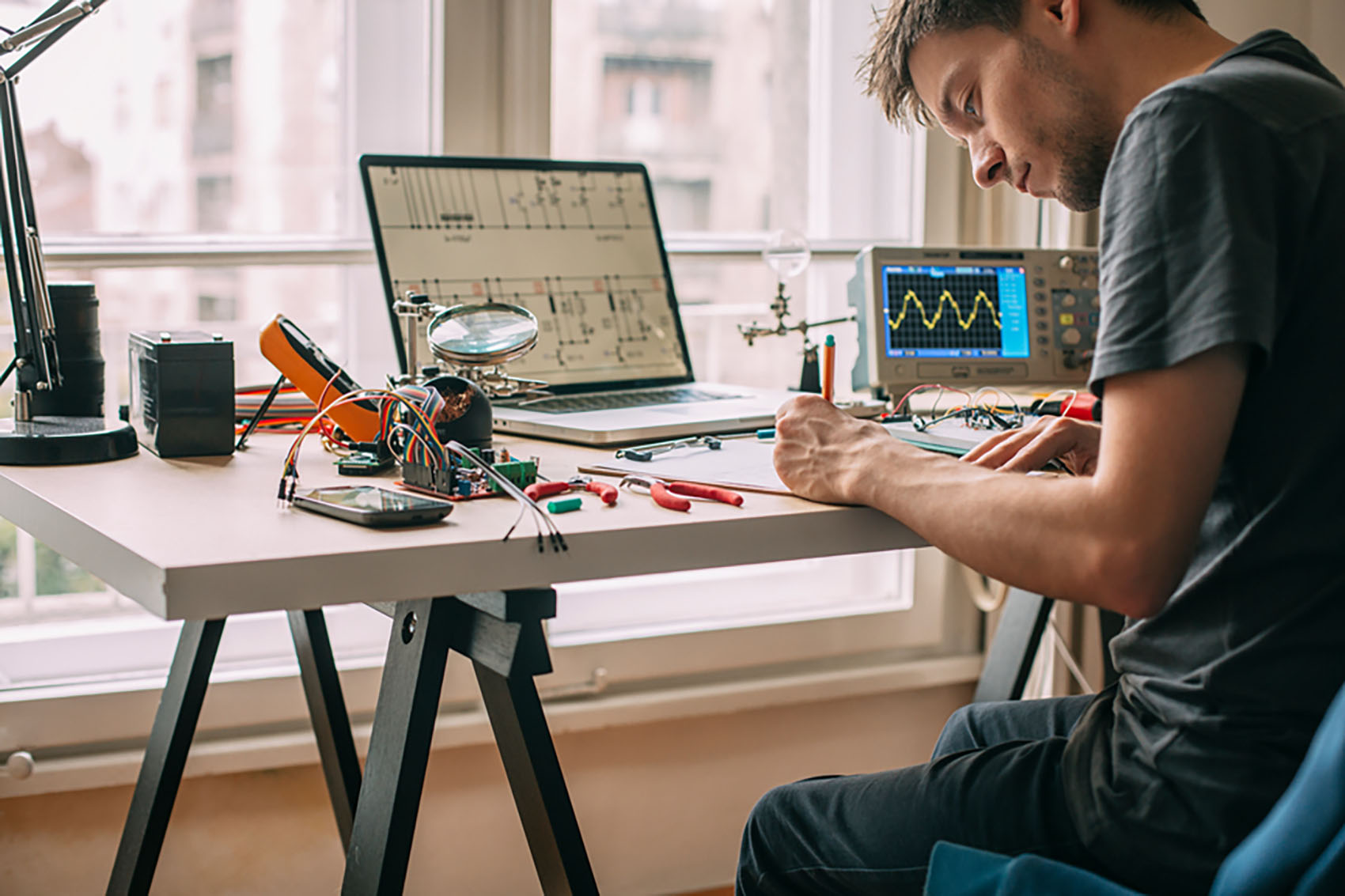 Young engineer testing electronic equipment at home.