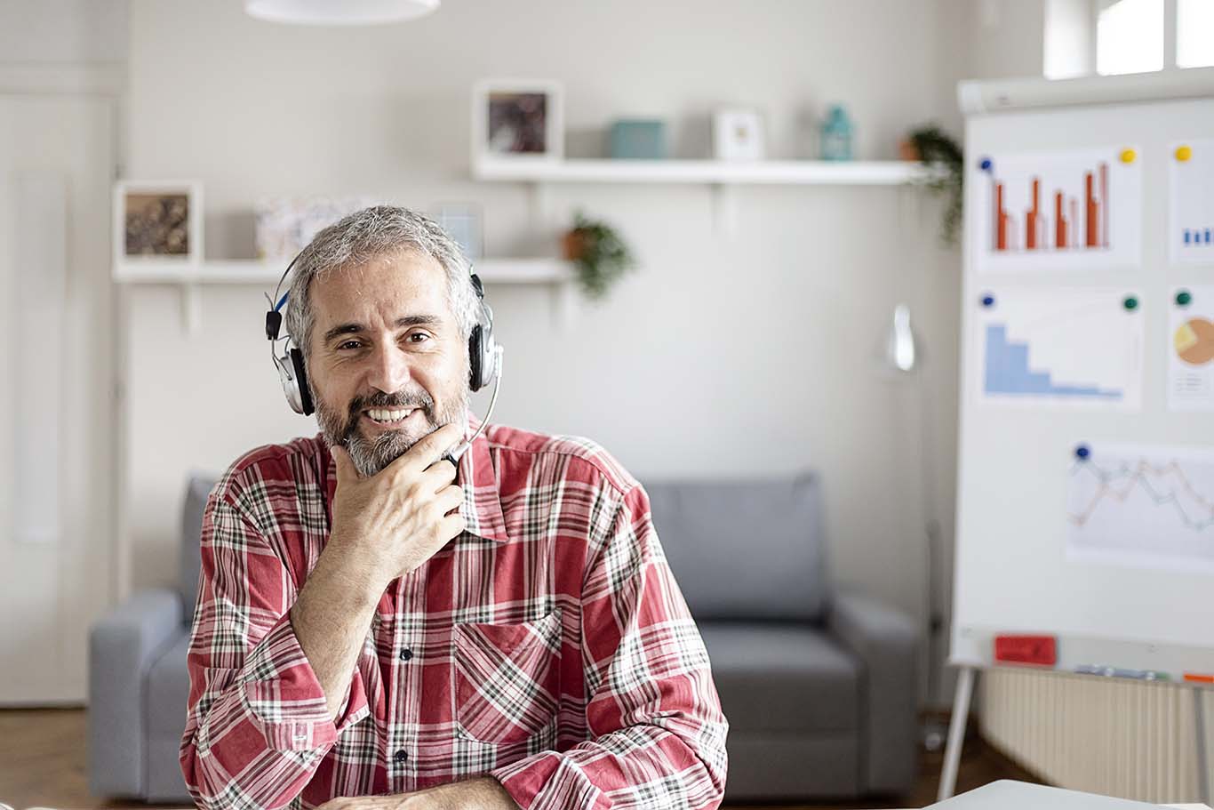 Businessman with headphones participating in a virtual interview at home