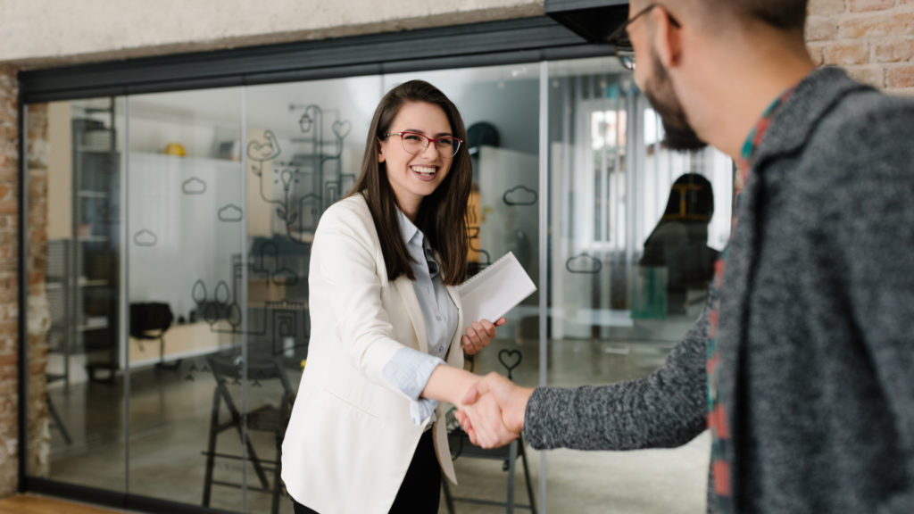 Woman shaking the hand of her interviewer in an office