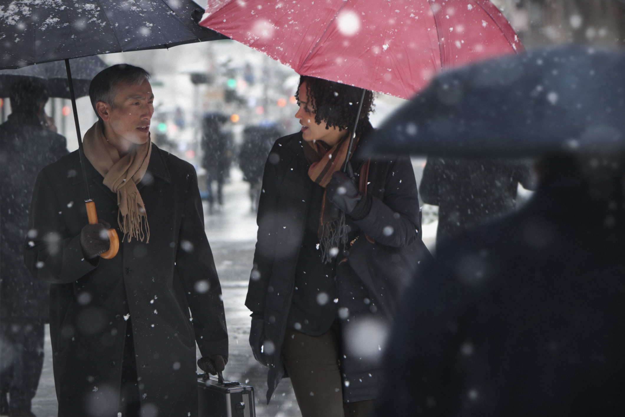 Two people talking while walking through the snow