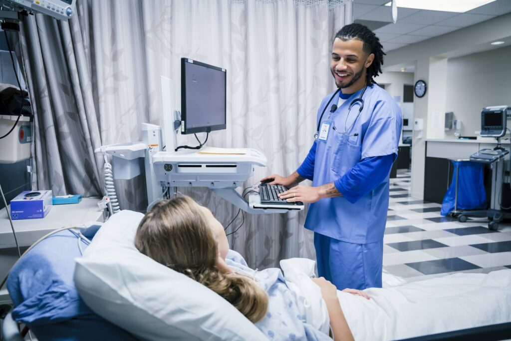 Nurse smiling at patient in bed