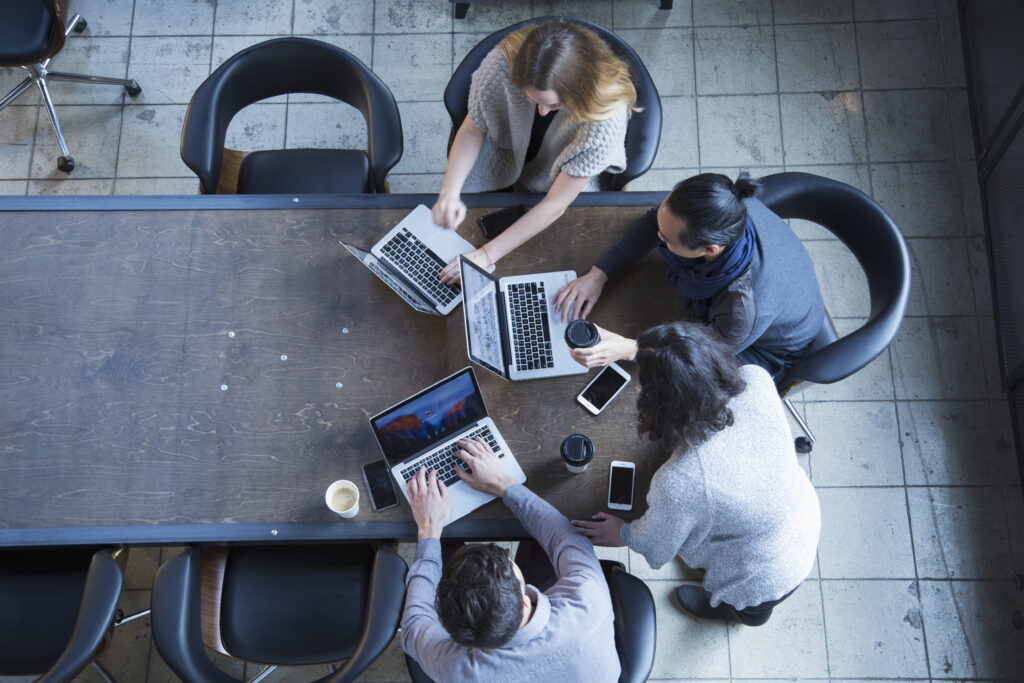 Huddled around laptops during a meeting