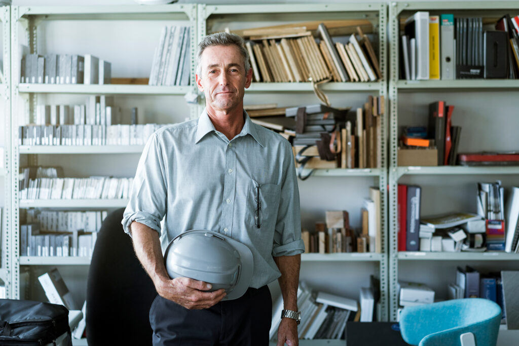 Construction worker in office holding hard hat