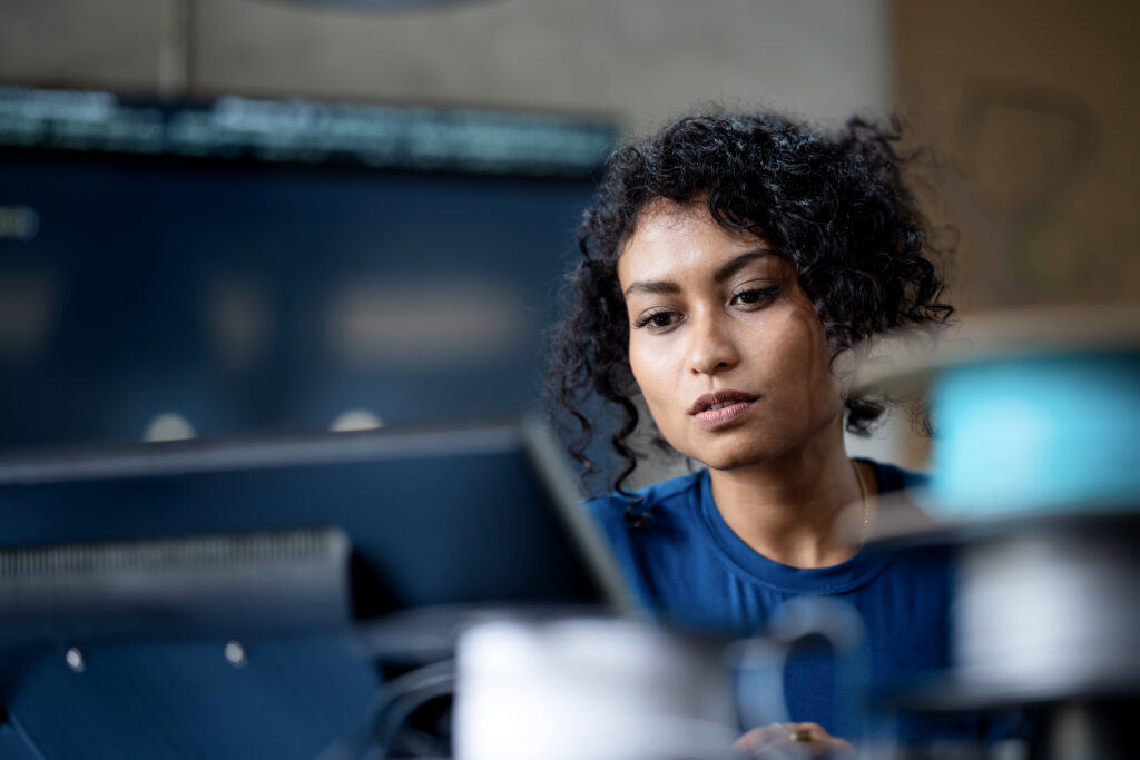 Software engineer reviewing systems technology in the office while looking at a computer